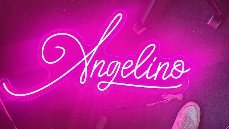 Logo "Angelino" en écriture blanche lumineuse sur fond violet.